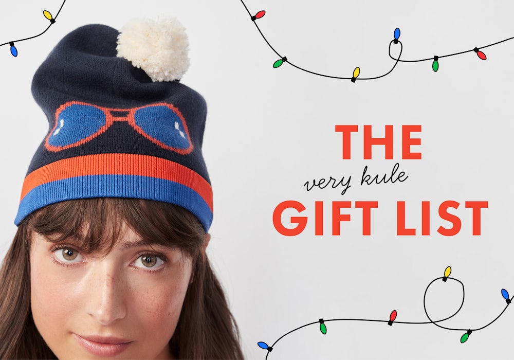  Image of KULE model wearing Ski Hat surrounded by twinkling Christmas lights. Click to shop the very KULE Gift List.